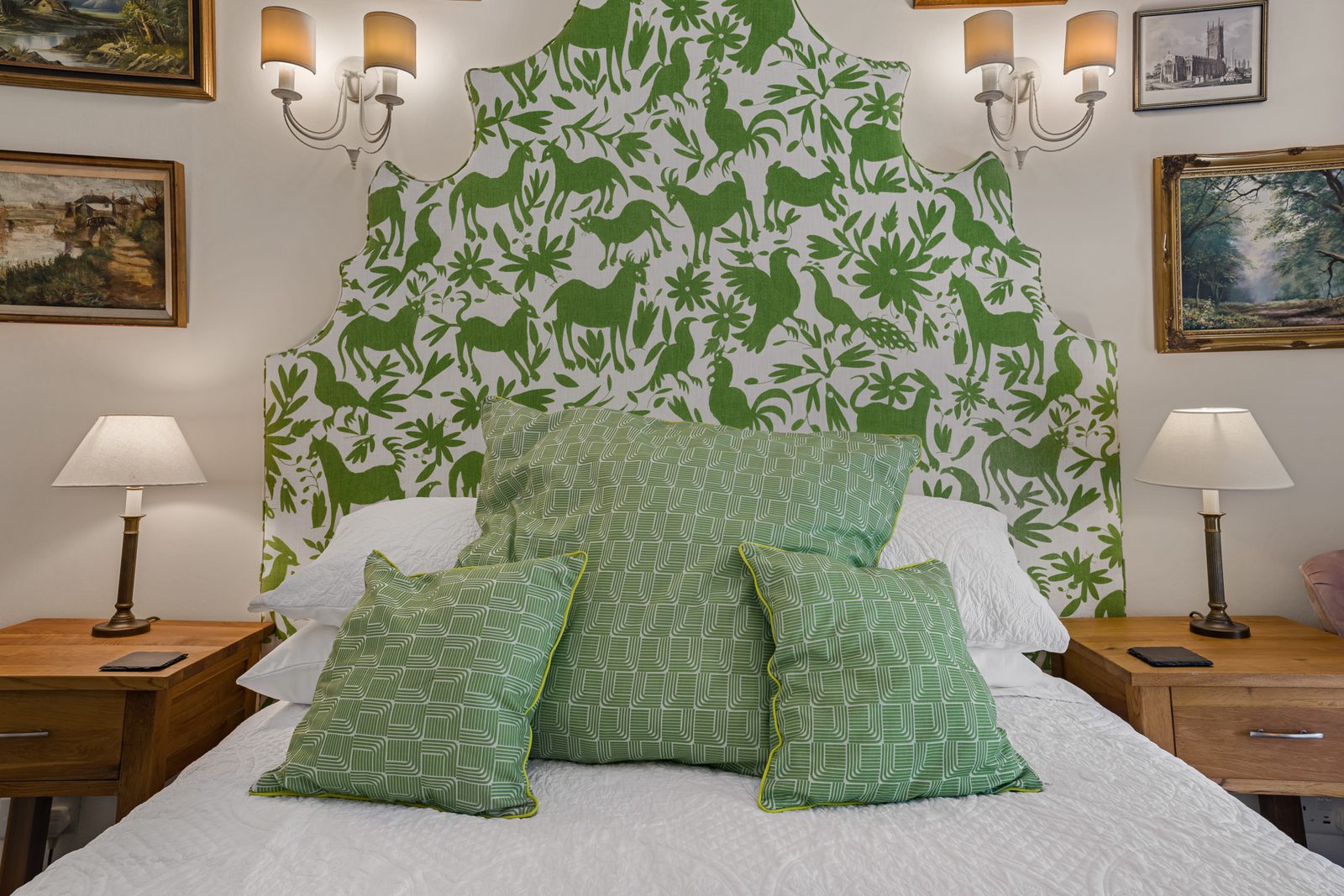 King-size bedroom at Green Hideaway with green botanical headboard and paired lamps