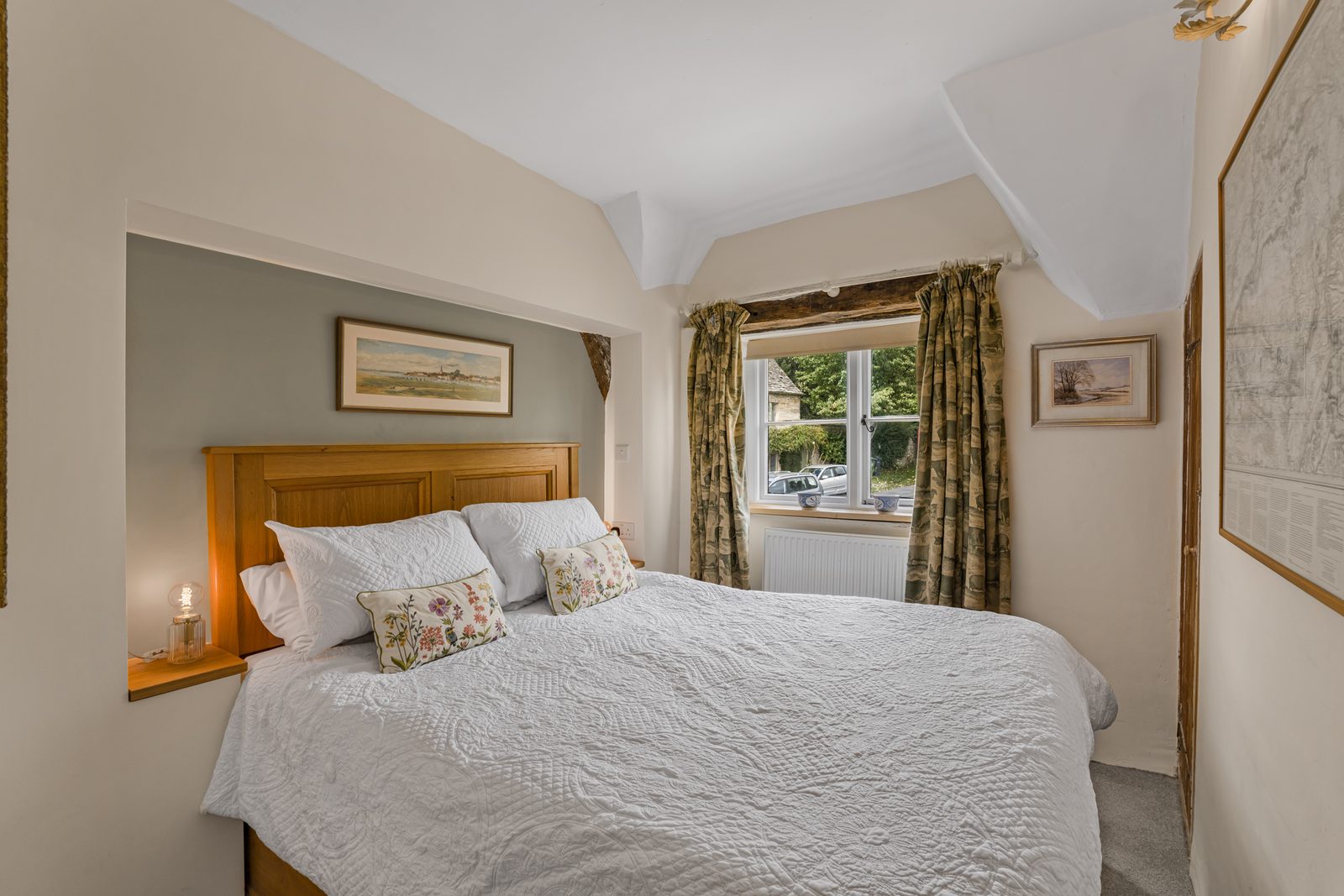Second king-size bedroom at Green Hideaway with oak headboard against a sage wall