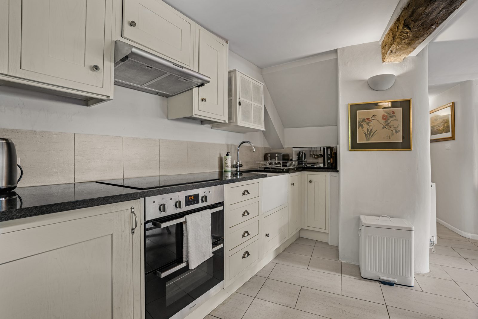 Cream shaker kitchen at Green Hideaway with granite worktop and oven under the beams