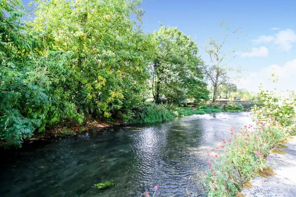 The River Coln in summer with overhanging trees