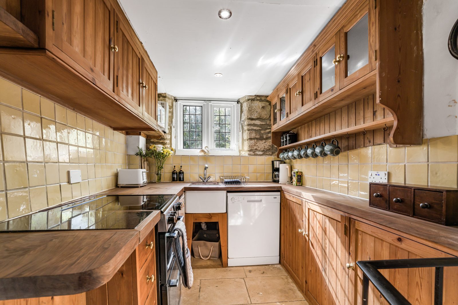 Kitchen at Riverside Cottage with solid wood units and a window over the sink