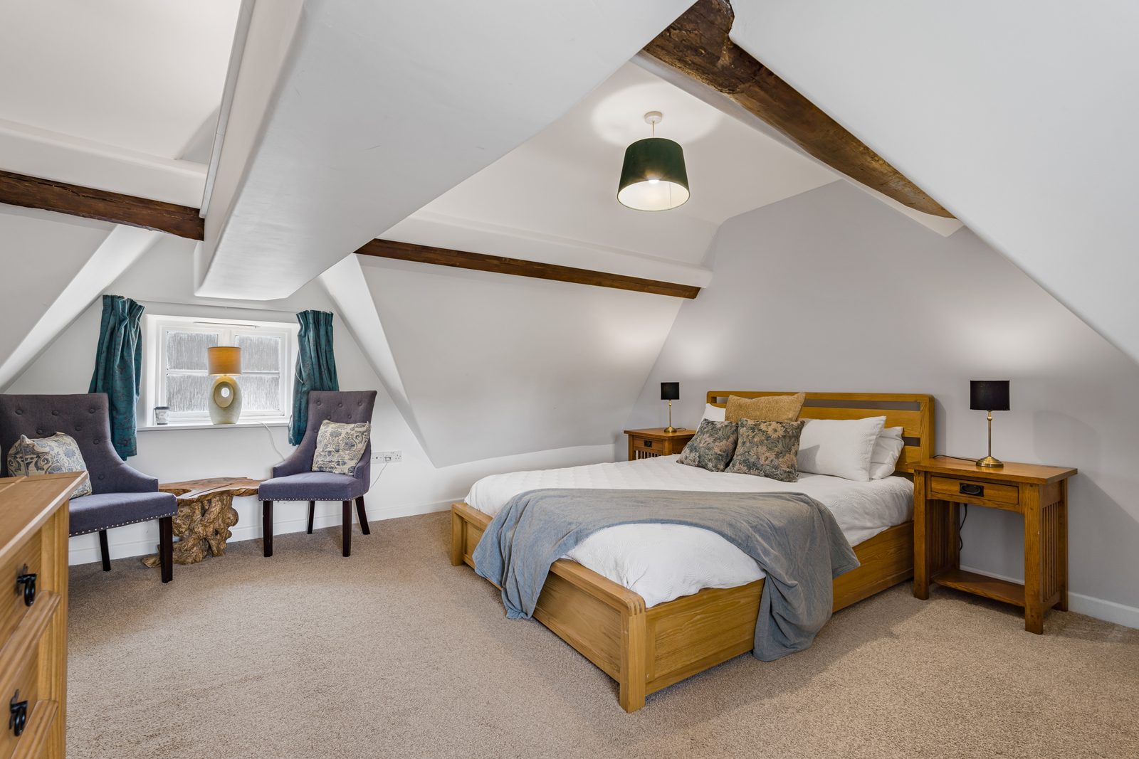 Top floor bedroom at Rosemary Cottage with velvet chairs beneath the roof slope